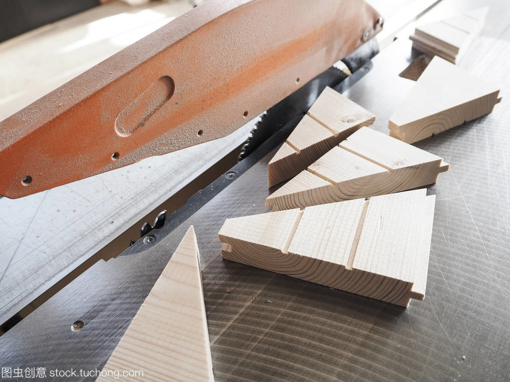 切在机器上的木结构部分。从顶视图。木制零件躺在家具生产中的圆锯片